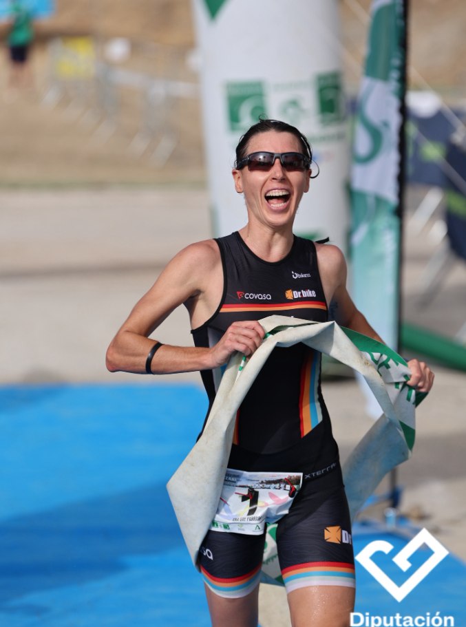 Ana Gay laughing as she breaks the finish tape